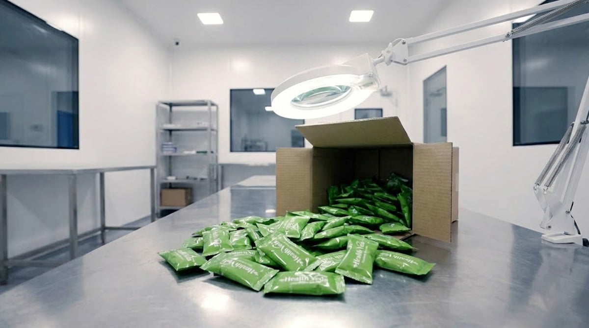 Green HealthVeda wrappers gathered beside an open carton in the packing area.