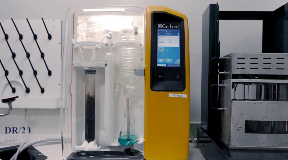 Laboratory equipment with glassware and a digital control panel.